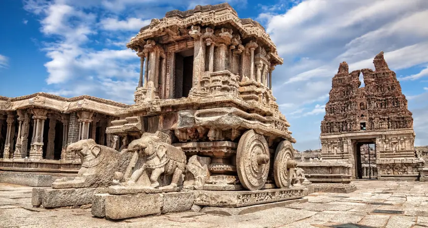 Stone chariot and ancient temple ruins under a blue sky